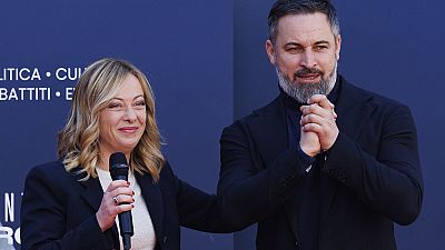Leader of the Spanish far-right VOX party Santiago Abascal, right, stands on the stage with Italy's Prime Minister Giorgia Meloni during a Brothers of Italy party celebration 