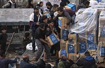 Palestinesi saccheggiano un camion di aiuti umanitari mentre attraversa la Striscia di Gaza a Rafah, domenica 17 dicembre 2023.
