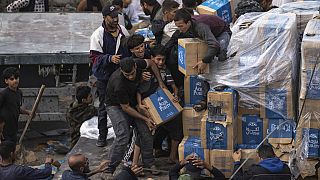 Un grupo de palestinos saquean un camión de ayuda humanitaria mientras cruzaba hacia la Franja de Gaza en Rafah, el domingo 17 de diciembre de 2023.