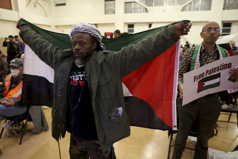 Elinde Filistin bayrağı bulunan Jabari Shaw isimli siyah Amerikalı bir kişi, İsrail ile Hamas arasında ateşkes olması için eylem yaparken