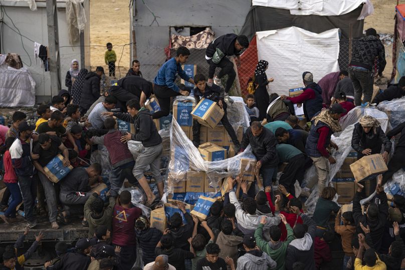 Palestinians loot a humanitarian aid truck as it crossed into the Gaza Strip in Rafah as supplies run dangerously low
