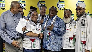  رئيس جنوب إفريقيا سيريل رامافوسا (ثالث من اليسار) وأعضاء مجلس العلماء المتحد بجنوب إفريقيا في المؤتمر الصحفي المشترك في جوهانسبرغ- 18 ديسمبر 2023.
