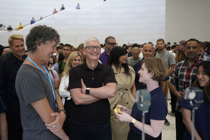 Apple CEO Tim Cook looks at new Apple watch models at an event in 2022.