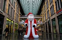 A likeness of Santa Claus stands outside a shopping mall in Berlin on December 24, 2021. John MACDOUGALL / AFP