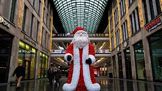 Uma imagem do Pai Natal à porta de um centro comercial em Berlim, a 24 de dezembro de 2021\. John MACDOUGALL / AFP