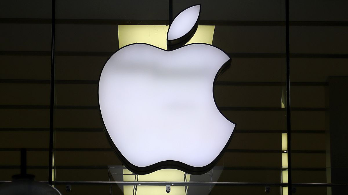 Το λογότυπο της Apple φωτίζεται σε ένα κατάστημα στο κέντρο της πόλης του Μονάχου, στη Γερμανία. 16 Δεκεμβρίου 2020.