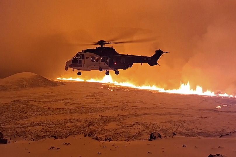 Un hélicoptère des garde-côtes islandais vole près du magma sur une colline près de Grindavík, dans la péninsule de Reykjanes, en Islande, le 18 décembre 2023.