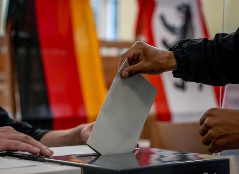 ARCHIVO - Un hombre deposita su voto para las elecciones alemanas en un colegio electoral de Berlín, Alemania, el domingo 26 de septiembre de 2021.