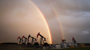 A rainbow appears to come down on pumpjacks drawing out oil and gas from wells near Calgary, Alberta, Monday, Sept. 18, 2023.