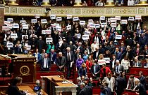Left-wing coalition NUPES members of parliament hold signs reading "Liberte", "Egalite", "fraternite" in the French National Assembly. 