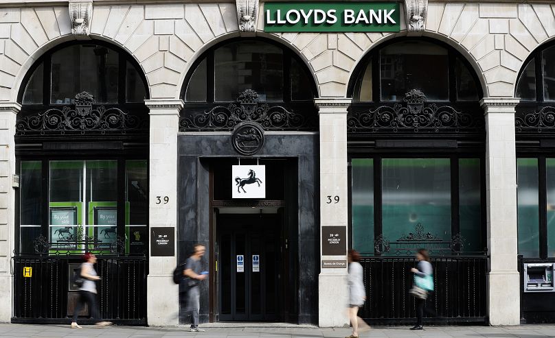 Pedestrians pass a branch of Lloyds Bank in London.