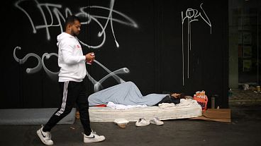 A rough sleeper lays on a mattress as a makeshift bed, in Whitechapel, east London on September 28, 2023.