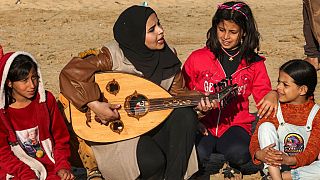 Gaza: Woman plays oud for displaced children to block out sound of war