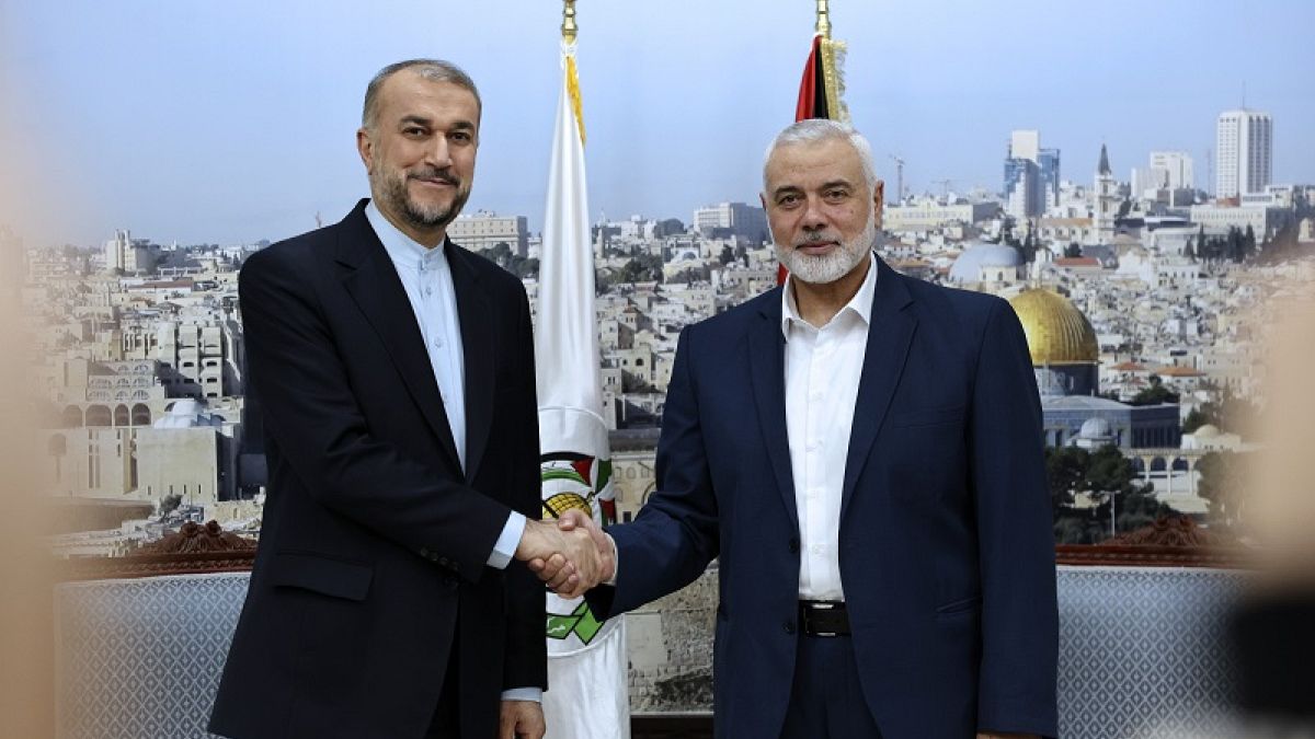 El ministro de Relaciones Exteriores de Irán, Hossein Amirabdollahian, le da la mano al jefe de Hamas, Ismail Haniyeh, durante su reunión en Doha, Qatar, el 20 de diciembre de