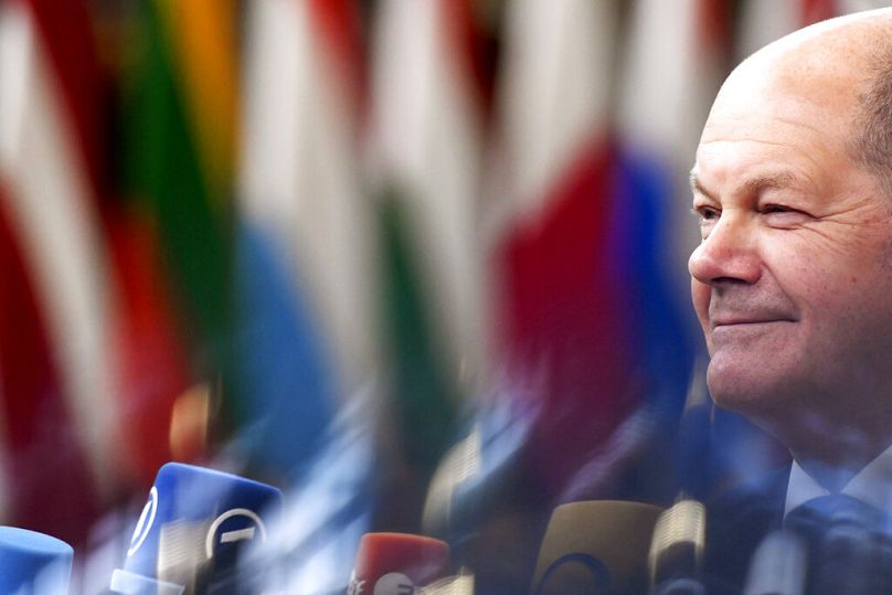 Germany's Chancellor Olaf Scholz speaks with the media as he arrives for an EU summit to debate gas price caps in Brussels, October 2022