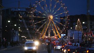 Traffic makes its way past a ferris wheel at one of the capital's many Christmas markets in front of the and the former east German parliament, the Palast der Republic, 06 Dec