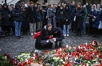 Mourners lay candle lights outside the headquarters of Charles University for victims of mass shooting in Prague, 22 December 2023