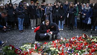 Mourners lay candle lights outside the headquarters of Charles University for victims of mass shooting in Prague, 22 December 2023