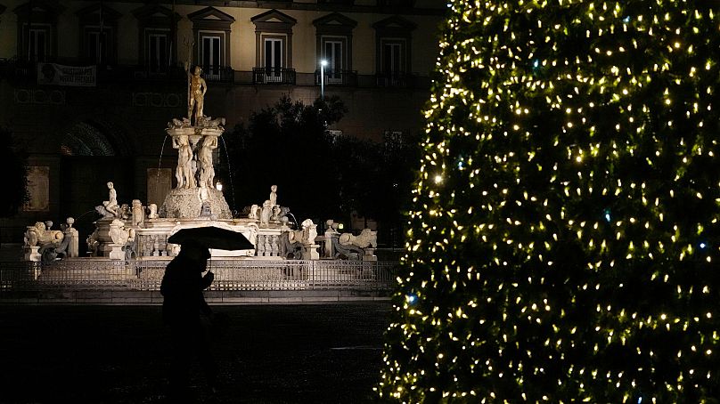 The lights of a Christmas tree are backdropped by the Neptune fountain in Naples, Italy, December 2021.