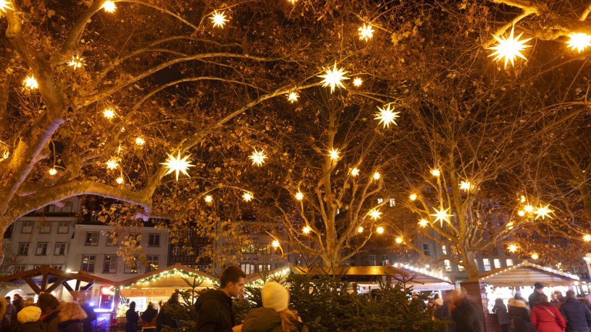 Nachts erleuchten Sterne den Weihnachtsmarkt in Straßburg.