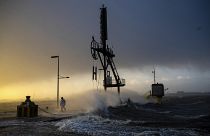 A person walks along the banks of the Weser estuary during a storm surge and waves in Bremerhaven, Germany, Friday 22 Dec 2023