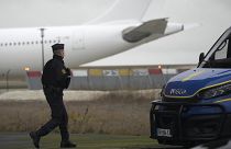 Un gendarme marche devant l'avion qui aurait transporté quelque 300 citoyens indiens, à l'aéroport de Vatry, dans l'est de la France, samedi 23 décembre 2023.