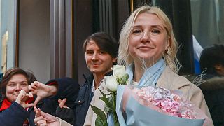 Yekaterina Duntsova, 40-year-old independent politician, holds flowers and poses with supporters outside the Central Election Commission in Moscow, 23 December, 2023