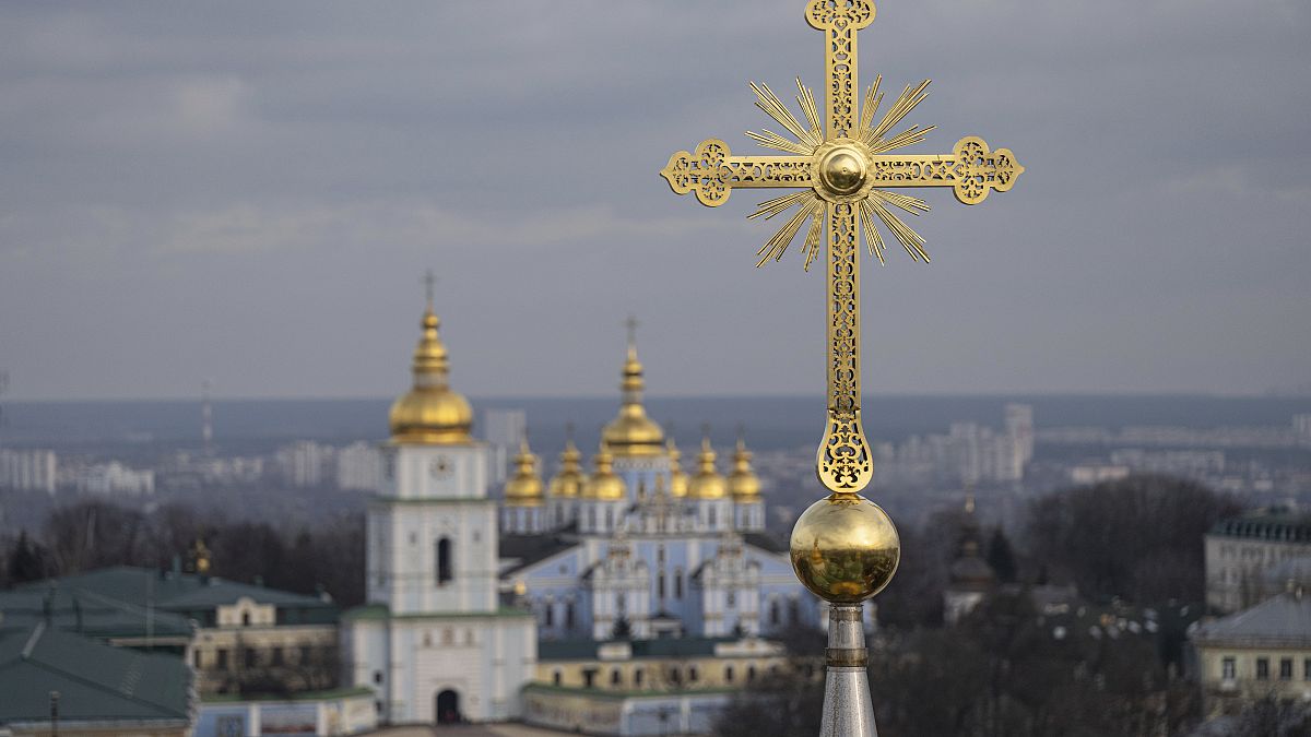 Une croix restaurée de la cathédrale Sainte-Sophie est visible devant le monastère à dôme d'or de Saint-Michel à Kiev, en Ukraine, le jeudi 21 décembre 2023.
