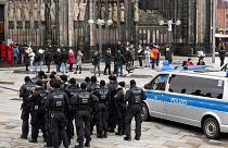 Des policiers patrouillent à l'entrée de la cathédrale de Cologne avant la messe de la veille de Noël, à Cologne, en Allemagne, le dimanche 24 décembre 2023.