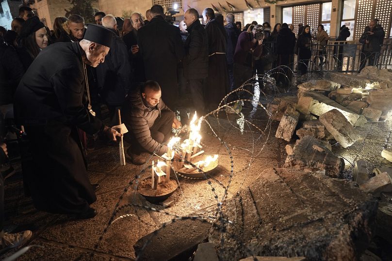 عکس آرشیوی از روشن کردن شمع مقابل کلیسیایی درکرانه باختری به یاد قربانیان غزه