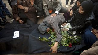 Palestinians mourn relatives killed in the Israeli bombardment of the Gaza Strip outside a morgue in Khan Younis on Sunday, Dec. 24, 2023