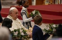 Папа римский Франциск держит статую младенца Иисуса во время рождественской мессы в соборе Святого Петра в Ватикане.