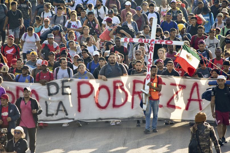 «Έξοδος από τη φτώχεια» γράφει το πανό που κρατάνε οι μετανάστες