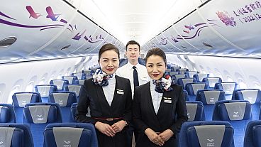 Members of the aircraft crew pose for photographs inside the Chinese-made C919 at the Hong Kong International Airport