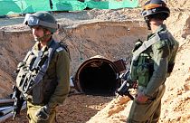 Gazze'deki tünellerden birinin önünde duran iki İsrailli asker