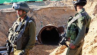 Gazze'deki tünellerden birinin önünde duran iki İsrailli asker