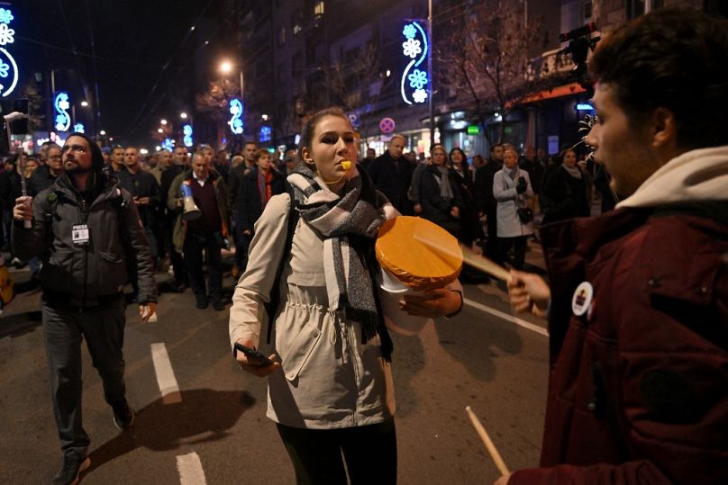 A demonstrator blows a whistle as opposition supporters take part in a march during a protest in Belgrade, on December 25, 2023, a week after the generl election.