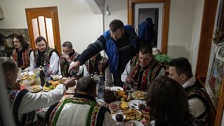 Hombres vestidos en atuendos tradicionales hutsuls festejan durante una celebración navideña en el pueblo de Kryvorivnia, en Ucrania