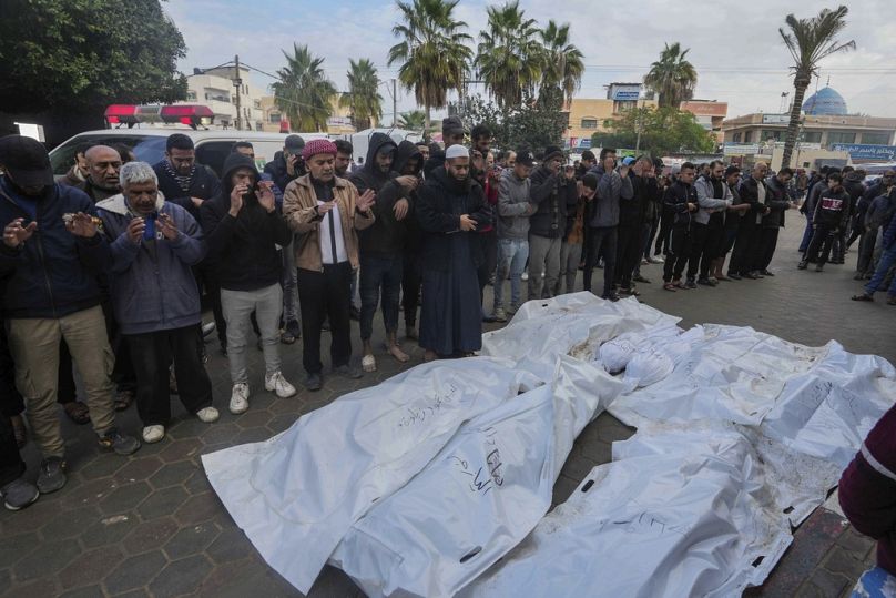 Palestinians mourn their relatives killed in the Israeli bombardment of the Gaza Strip, in Deir al Balah, Gaza Strip, on Monday, Dec. 25, 2023.