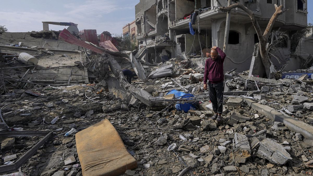 Palestinesi ispezionano le macerie di un edificio della famiglia Al Nawasrah distrutto da un attacco israeliano nel campo profughi di Maghazi, nella Striscia di Gaza centrale,