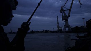 Un oficial de las Fuerzas de Operaciones Especiales de Ucrania habla por radio mientras navega por el río Dnipro durante una misión nocturna en Ucrania.