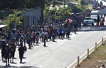 Migrants walk along a highway in Huixtla, Mexico, Monday, Dec. 25, 2023