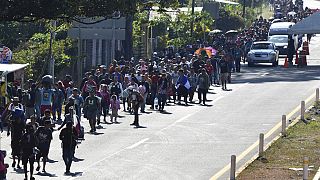 Migrants walk along a highway in Huixtla, Mexico, Monday, Dec. 25, 2023