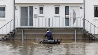 Un hombre rema en un bote de goma a través de un área inundada en Beverungen, Alemania, el martes 26 de diciembre de 2023.