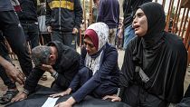Relatives mourn over the body of a loved one killed during Israeli bombardment at Nasser Hospital in Khan Yunis 