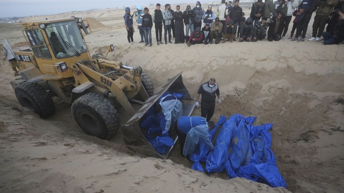 Un bulldozer décharge les corps des Palestiniens tués dans le nord de la bande de Gaza et remis à l'armée israélienne lors de funérailles collectives à Rafah, 