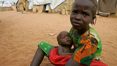 Una niña sudanesa con su hermanita en las afueras de la ciudad occidental de El-Geneina, cerca de la frontera con Chad, el 25 de octubre de 2004.