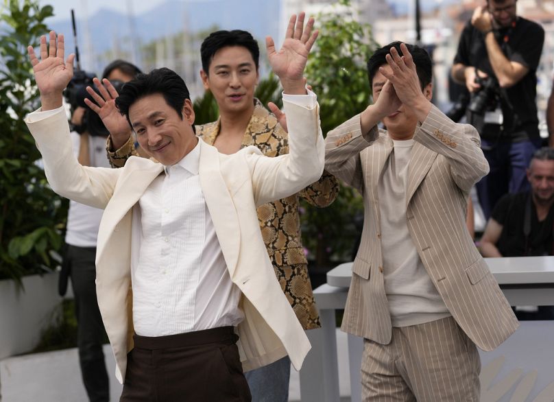 Lee Sun-kyun (solda) Cannes Film Festivali'nde 'Project Silence' filmi için yapılan fotoğraf çekiminde poz veriyor.
