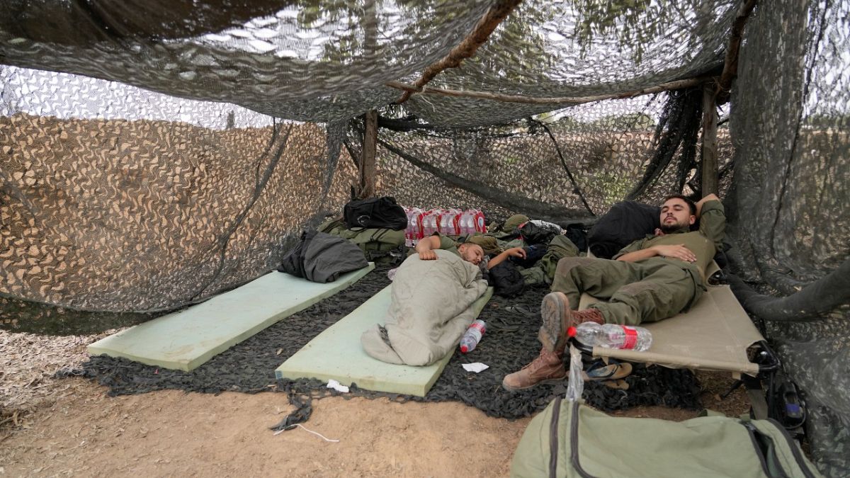 جنود إسرائيليون يستريحون بالقرب من الحدود بين إسرائيل وغزة.