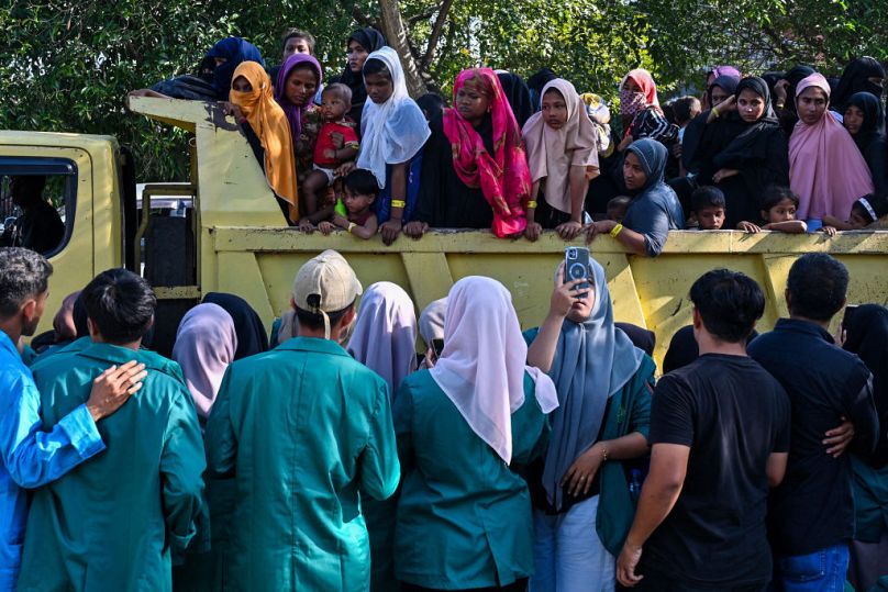 Rohingya refugees crowd into a vehicle for relocation to a nearby government building after demonstrating university students forced them out of their temporary home